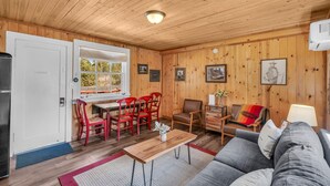 A cozy cabin interior with a dining area, a living room with a sofa, and a kitchen area. - FreeSpirit Cabin| Your Zion National Park Retreat (Orderville)