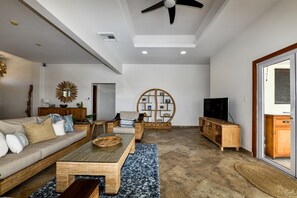 Un salón amplio con sofá, mesa de centro y mueble para la televisión.