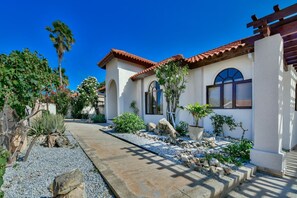 A house with a tiled roof, arched windows, and a gravel pathway leading to the entrance. - Pool Oasis: 3BR Home w/ Patio near Arashi Beach (Noord)