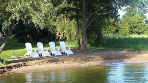 A riverside area with white chairs arranged for seating.