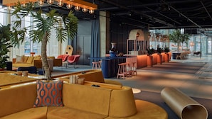 A modern lounge area with seating, a bar, and large windows. - Scandic Goteborg Central (Gothenburg)