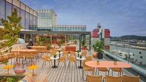 A rooftop terrace with outdoor seating, potted plants, and a view of the cityscape. - Scandic Goteborg Central (Gothenburg)