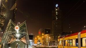 A tram station with a distinctive metal structure and a tram in the background. - ShortStayPoland Panska (Warsaw)