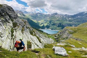 Un paysage montagneux avec un randonneur et un lac dans la vallée.