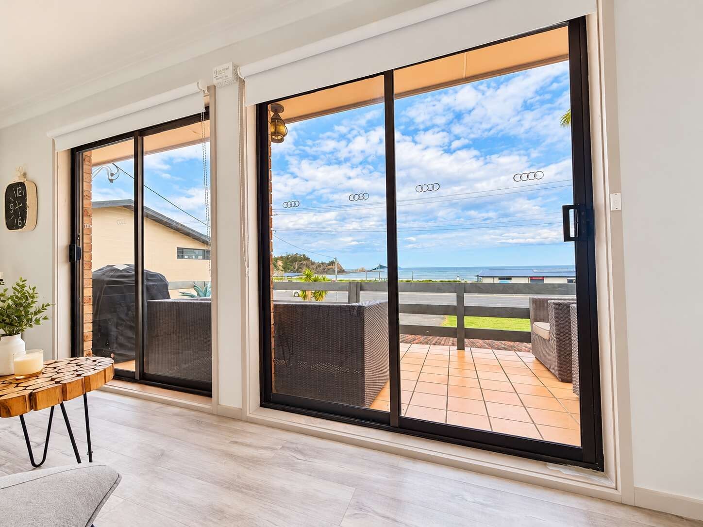 A modern interior with a large sliding glass door leading to an outdoor patio area.