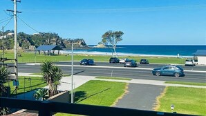 A coastal road with cars, a clear sky, and a view of the ocean. - Malua Bay Beach house (MALUA BAY)