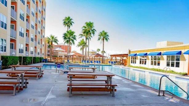 A hotel pool area with lounge chairs and a swimming pool.