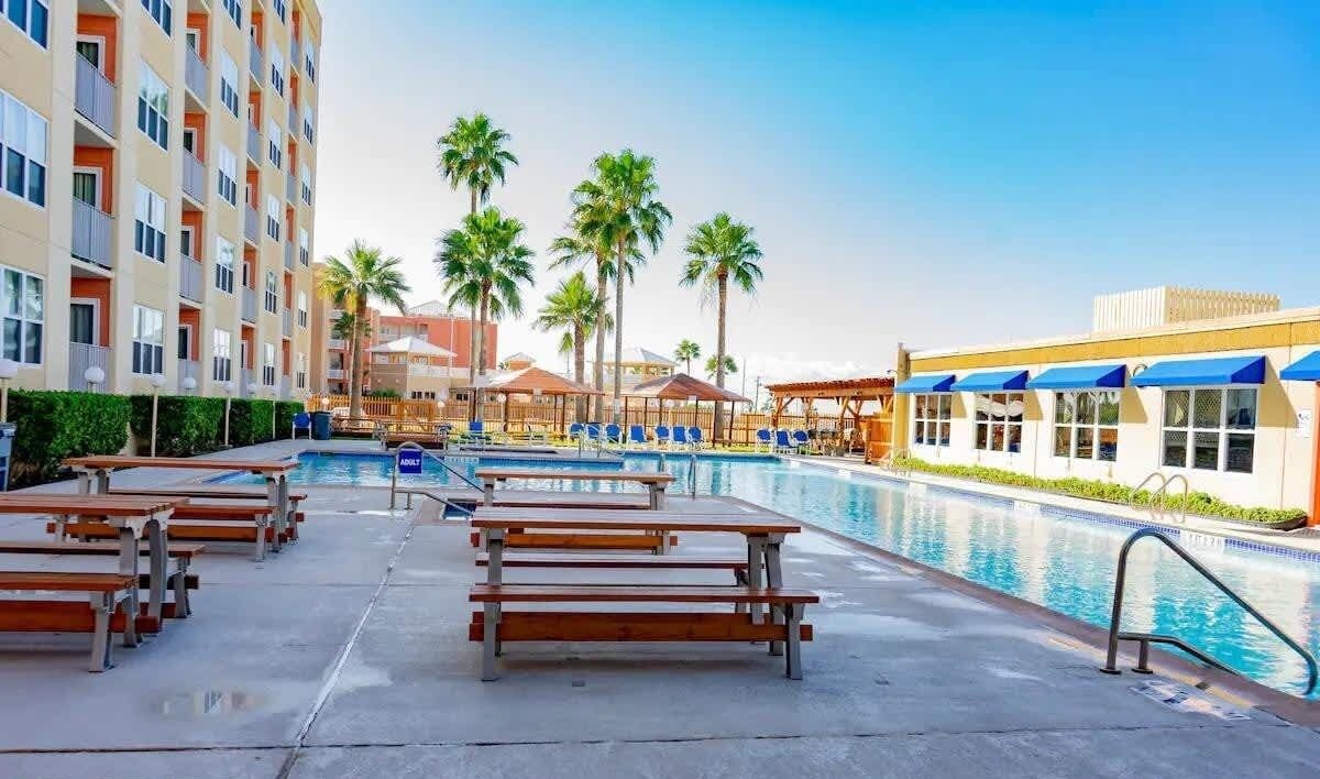 Un espace piscine d’hôtel avec des chaises longues et une piscine.