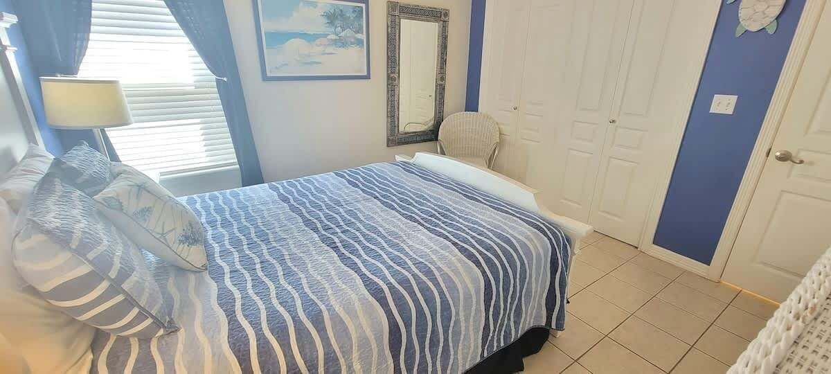 Une chambre à coucher avec un lit, une chaise, une lampe et une porte.