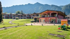 A hotel with a central courtyard, outdoor seating, and mountain views. - Apartment by Lake Idro with Mountain Views (Idro (bs))