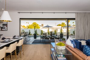 A modern living room with a sofa, coffee table, and dining area with chairs and a table. - Modern Luxury Near Old Town Scottsdale - Private Pool & New Spa (Scottsdale)