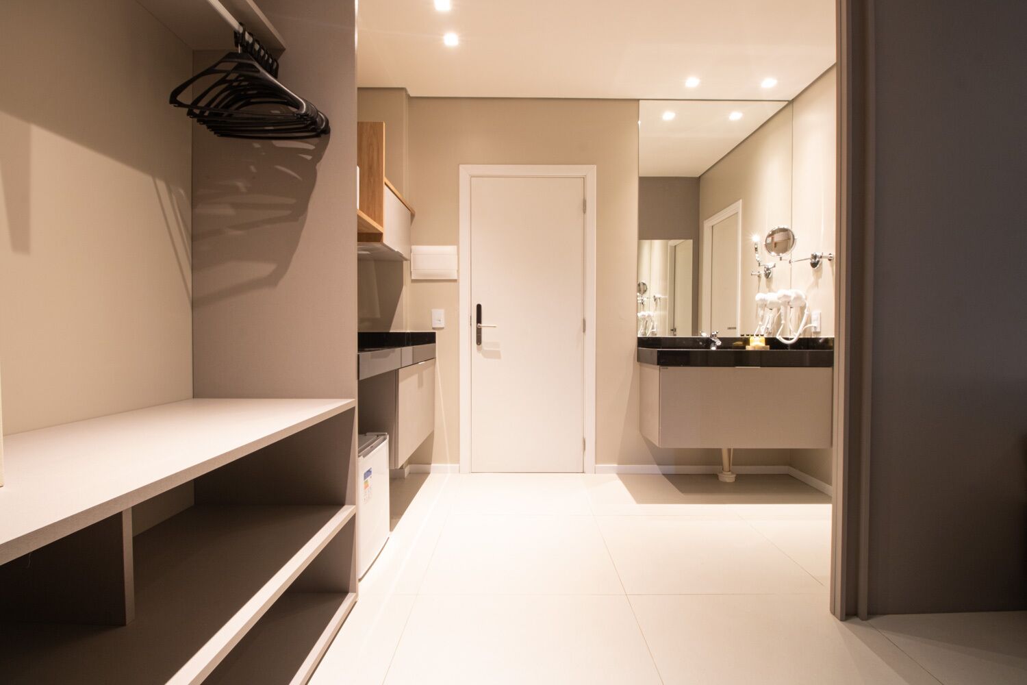Un baño moderno con lavamanos, espejo y barra para toallas blancos.