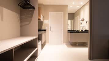 Un baño moderno con lavamanos, espejo y barra para toallas blancos.