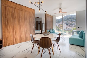 A modern dining area with a round table, chairs, and a ceiling fan.