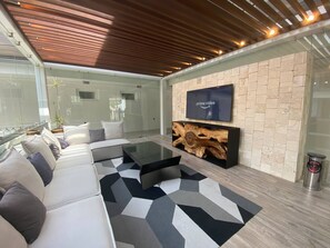 Una sala de estar moderna con un sofá seccional, una mesa de centro y un televisor montado.
