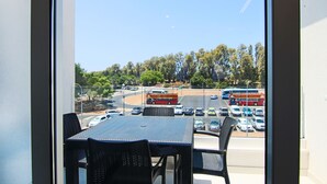 A view from a balcony with a table and chairs, overlooking a road with cars and buses. - Phaedrus Living: Seaside Executive Flat Harbour 207 (Paphos)