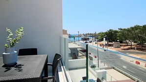 A balcony with a table, chairs, and a potted plant. - Phaedrus Living: Seaside Executive Flat Harbour 207 (Paphos)