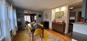 A dining area with a wooden table, yellow chairs, and a patterned rug. - Winter Lore (Rutland)