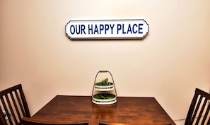 Una mesa de comedor con un letrero encima que dice "OUR HAPPY PLACE".
