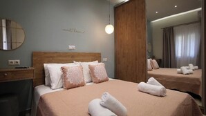 A hotel room with a large bed, two bedside tables, a mirror, and a wall with a 'sweet dreams' sign.