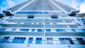A high-rise building with multiple balconies and large windows.