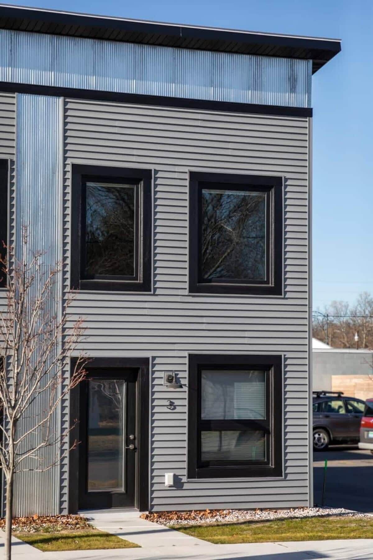 Un bâtiment moderne à deux étages, doté de grandes fenêtres et d’une façade en métal.