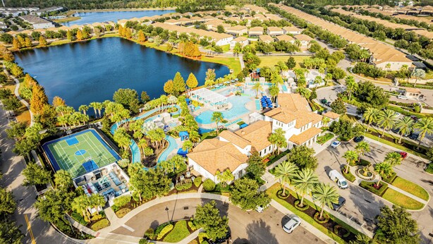 An aerial view of a residential area with a swimming pool, tennis court, and a large house with a garden. - Townhome with Star Wars Game Room, Private Pool, PS5 & Themed Bedrooms (Kissimmee)