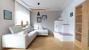 Een moderne woonkamer met een hoekbank, houten vloeren en een inbouwkasten voor entertainment.
