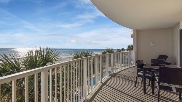 Un balcon avec vue sur la plage et l’océan.