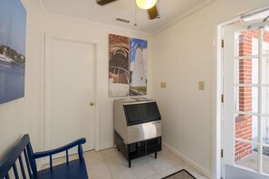 A room with a grill, a door, and a view of a brick building through a window. - Bluff Shoal Motel (Ocracoke)