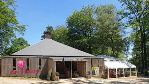 A rustic wooden building with a sign reading "RESTAURANT" and a covered outdoor seating area. - Treehouse & private SPA (4/5 peoples) (Noues de Sienne)