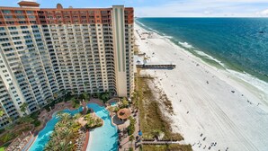 Ein Hochhaus-Hotel mit Poolbereich und Zugang zum Strand.