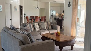 Un salon avec un canapé, une table basse et un ventilateur de plafond.