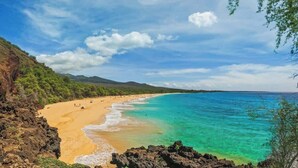 A beach with clear turquoise waters, a sandy shore, and a mountainous backdrop. - Wailea Luxury Retreat | Walk to Beach & Shops (Wailea-Makena)
