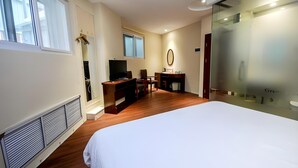 A hotel room with a large bed, a desk with a chair, a television, and a mirror. - Greentree Inn Qinhuangdao Changli County Railway S (Qinhuangdao)