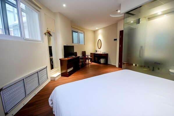 A hotel room with a large bed, a desk with a chair, a television, and a mirror. - Greentree Inn Qinhuangdao Changli County Railway S (Qinhuangdao)