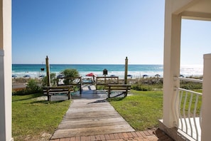 A wooden pathway leading to a beach with a clear view of the ocean.
