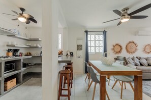 A modern kitchen with a dining area, built-in appliances, and a ceiling fan.