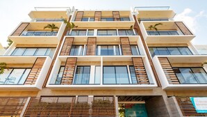 Ein mehrstöckiges Gebäude mit modernem Design, das große Fenster und Holzakzente aufweist.