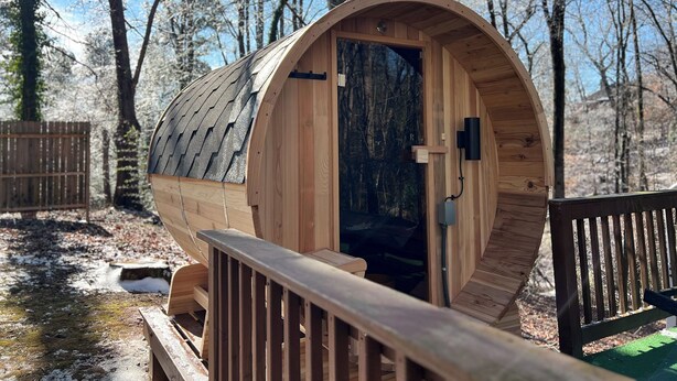 Eine Holzhütte mit gewölbtem Dach, einer Tür und einer kleinen Veranda.