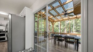 Eine moderne Küche mit einer Schiebetür zu einer Terrasse mit Sitzgelegenheit.