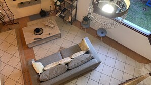 A modern living room with a grey sofa, a coffee table, and a hanging light fixture. - Villa Sea View (Saint-Leu)