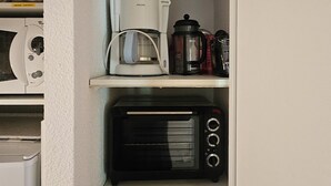 A kitchen with a microwave, coffee maker, toaster, and a set of utensils. - Apartment La Foux Heated pool access (La Foux d'Allos)