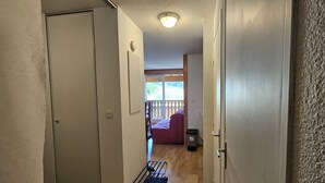 A hallway leading to a balcony with a view of a snowy landscape. - Apartment La Foux Heated pool access (La Foux d'Allos)