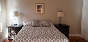 Cozy retreat with a large bed, bedside tables, and a framed picture.