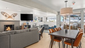 Una sala de estar moderna con chimenea, sofá, mesa de comedor y sillas.