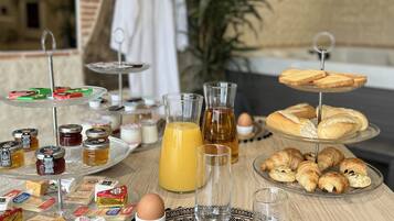 A breakfast setup with various food items and drinks on a table.