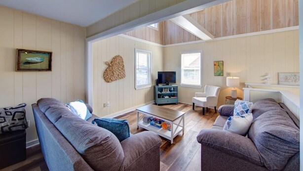 A living room with a sofa, armchair, and TV stand. - Ocean View- 5 min Walk to Beach, Volleyball (Kill Devil Hills)
