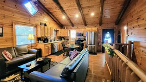 Un interior acogedor de cabaña con sala de estar, comedor y cocina.