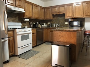 Enjoy cooking in this well-equipped kitchen with a central island, stainless steel appliances, and granite countertop.